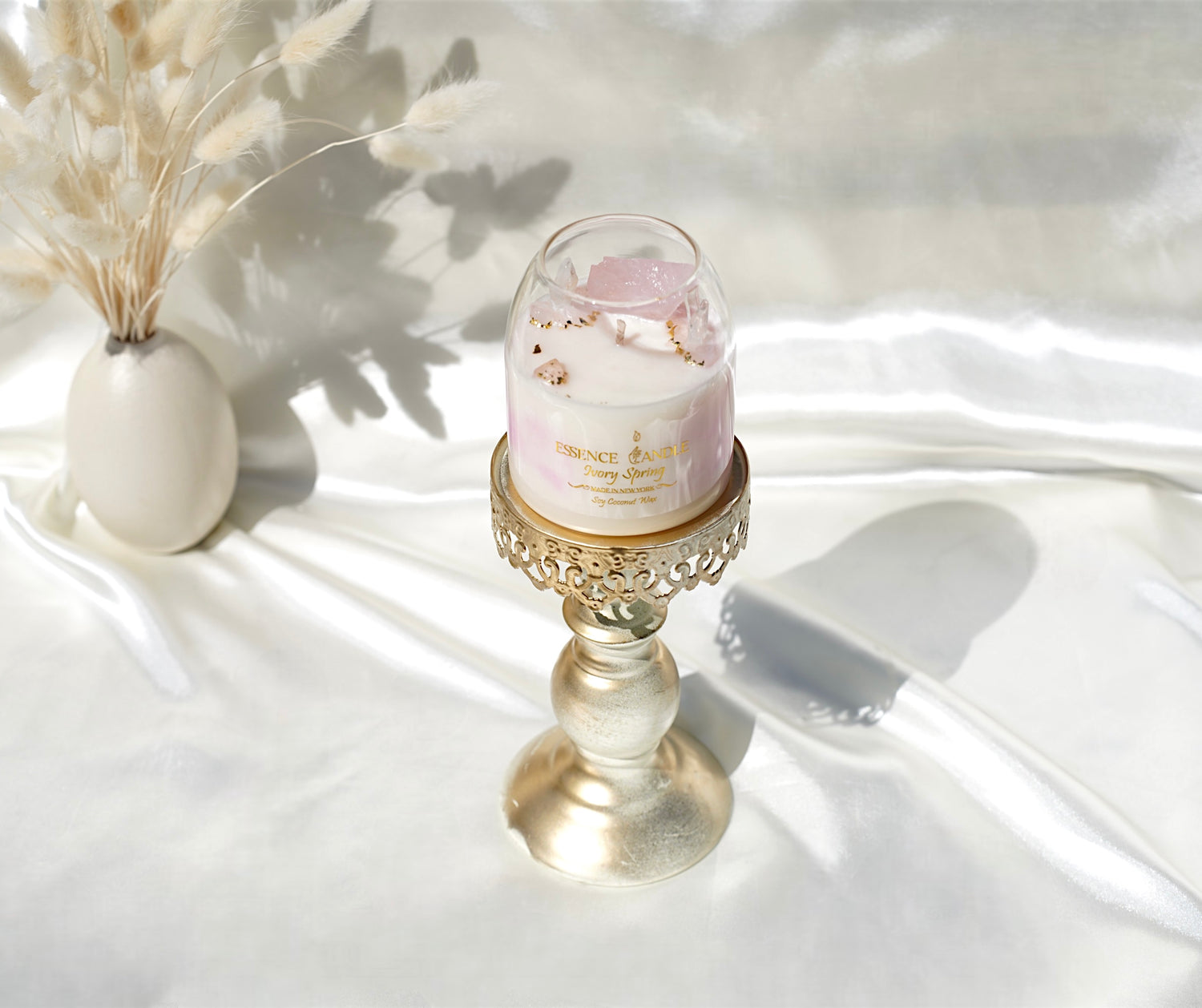 Luxury 17 oz Ivory Spring candle, infused with ylang ylang fragrance, rose quartz, and clear quartz. Eco-friendly soy coconut wax with gold accents, lasting double the usual time.